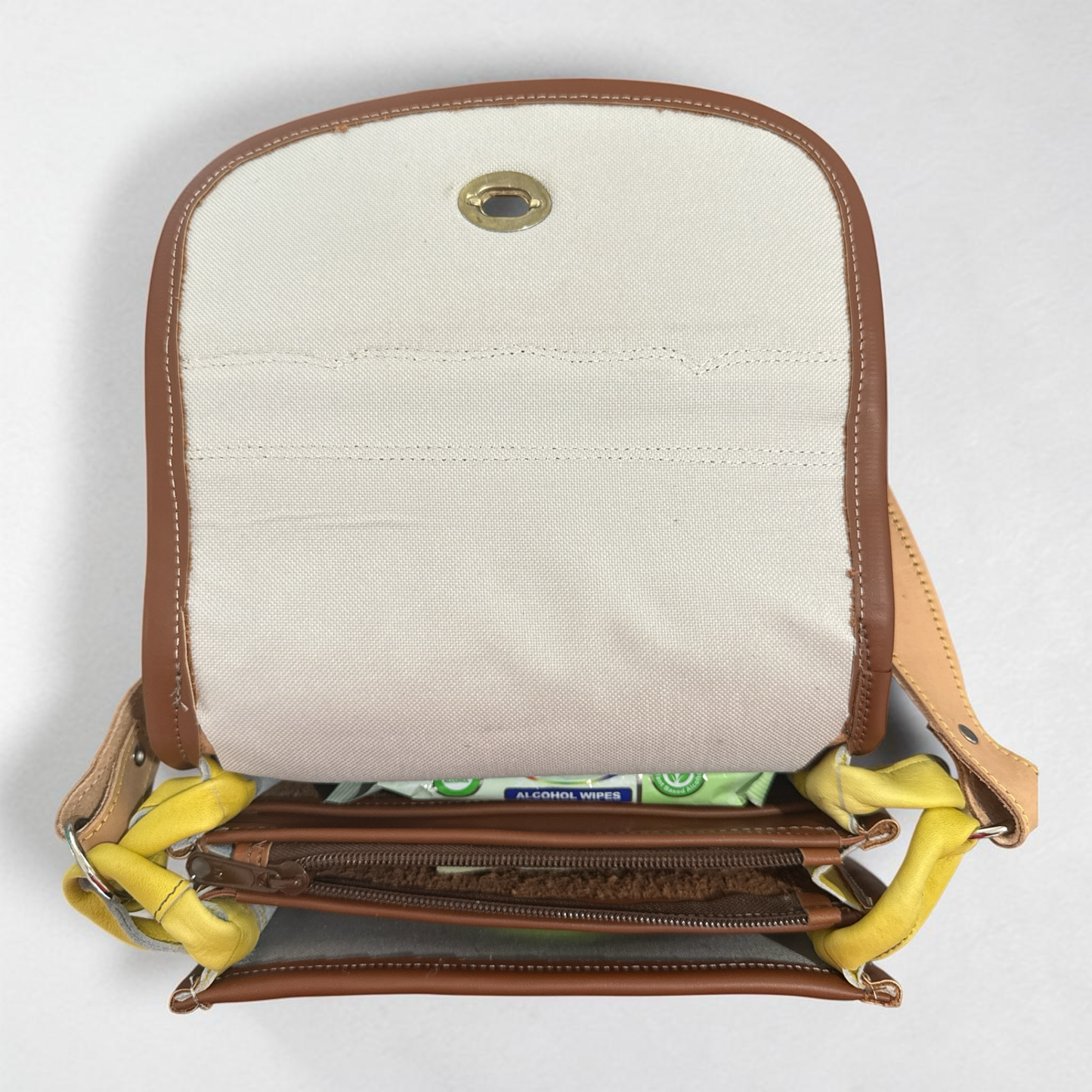 Hidden security pocket detail on compact leather bag
